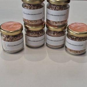 Sechs Gläser mit Eierschwammerlsalz auf einem Tisch, handgemachtes Naturprodukt aus Zell am See.