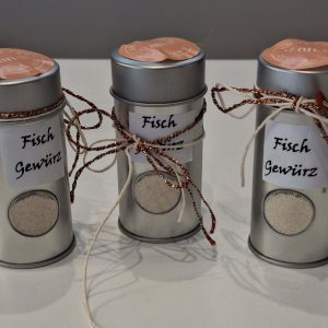 Drei Metallbehälter mit Beschriftung „Fisch Gewürz“ und dekorativen Bändern.