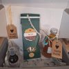 Handgemachte Naturprodukte in einer Geschenkbox mit Etiketten und buntem Inhalt.