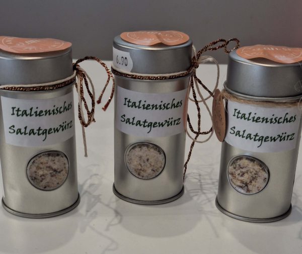 Drei Dosen mit italienischem Salatgewürz, dekorativ verpackt mit Etiketten und Kordel.