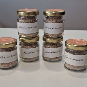 Sechs Gläser mit Kapuzinerkressesalz auf einem Tisch, handgemacht aus Zell am See.