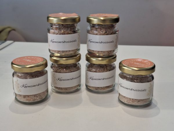 Sechs Gläser mit Kapuzinerkressesalz auf einem Tisch, handgemacht aus Zell am See.