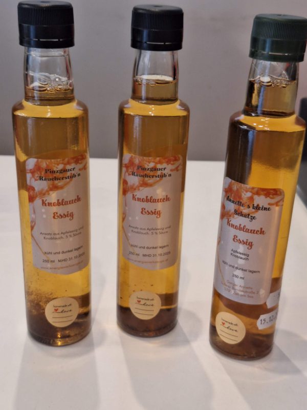 Drei Flaschen Knoblauch-Essig aus Zell am See, handgemacht und aromatisch verpackt.