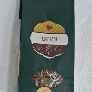 Kräutertee-Verpackung mit der Aufschrift "Kopf hoch" und Etikett "homemade with love".
