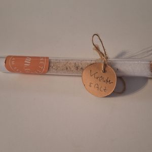 Klarer Glastest mit handgemachten Kräutersalz und Etikett, dekorativ verziert.