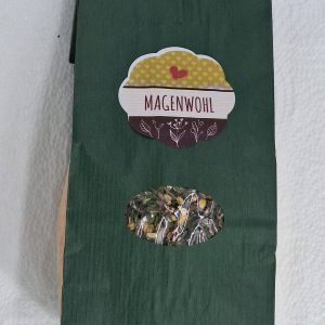 Kräutertee "Magenwohl" in grüner Verpackung mit Sichtfenster auf die Inhaltsstoffe.