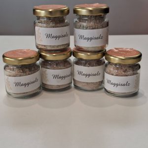 Sechs Gläser mit handgemachtem Maggischalz auf einem Tisch.