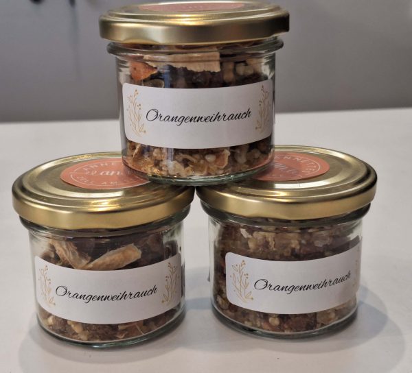 Drei Gläser mit handgemachtem Orangeneiweihrauch, etikettiert und liebevoll arrangiert.