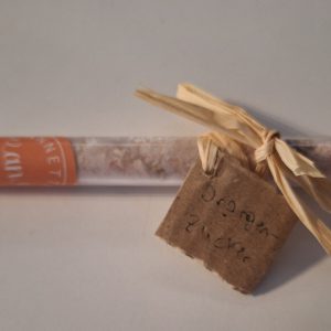 Röhrchen mit handgemachtem Orangen-Zucker, dekoriert mit einem gestripten Band.