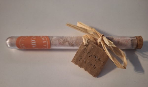 Röhrchen mit handgemachtem Orangen-Zucker, dekoriert mit einem gestripten Band.