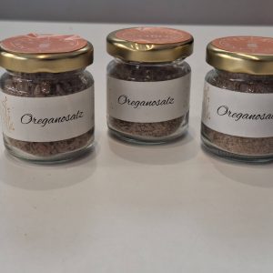 Drei Gläser mit Oreganosalz auf hellem Hintergrund, ideal für kreative Geschenke.