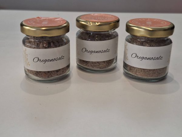 Drei Gläser mit Oreganosalz auf hellem Hintergrund, ideal für kreative Geschenke.