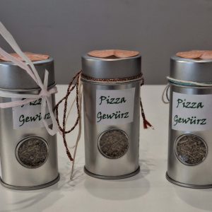 Drei Dosen mit handgemachtem Pizza-Gewürz, dekoriert mit Bändern und Etiketten.