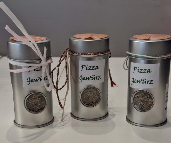 Drei Dosen mit handgemachtem Pizza-Gewürz, dekoriert mit Bändern und Etiketten.