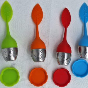 Bunte Teefilter in Blattform mit passenden Untersetzern, ideal für Teeliebhaber.