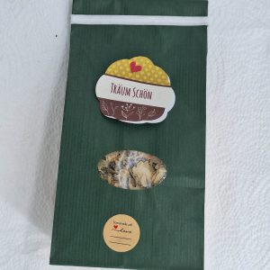 Grüne Verpackung mit Aufklebern für handgemachtes Kräuterprodukt "Träum Schön".
