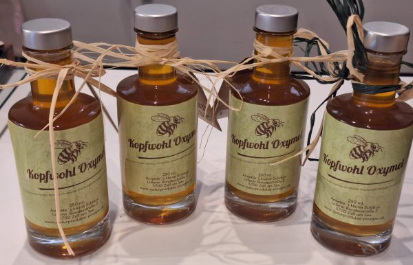 Handgemachte Flaschen mit Kopfwohl Oxymel, dekoriert mit Naturfasern und Etiketten.