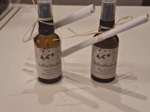 Salbeihydrolat in Glasflaschen mit dekorativen, weißem Papier und Bändchen, handgemacht in Zell am See.