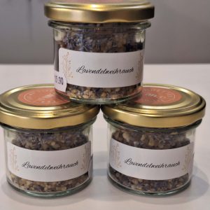 Drei Gläser mit Lavendelräucherwerk, etiketiert, auf einem Tisch platziert.