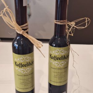 Zwei Flaschen handgemachter Kaffeelikör mit dekorativem Etikett und Schleife.